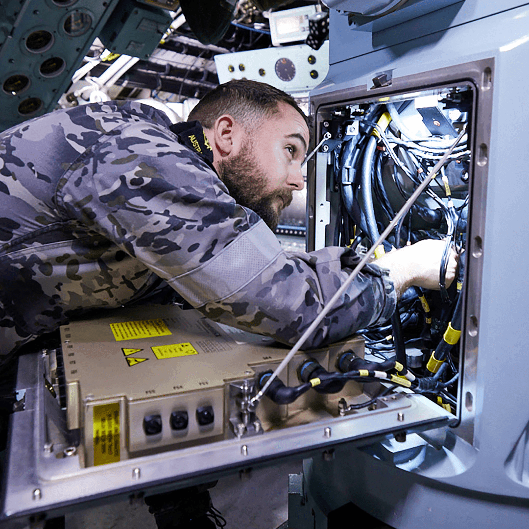 A male Air Force mechanic is working on some equipment.