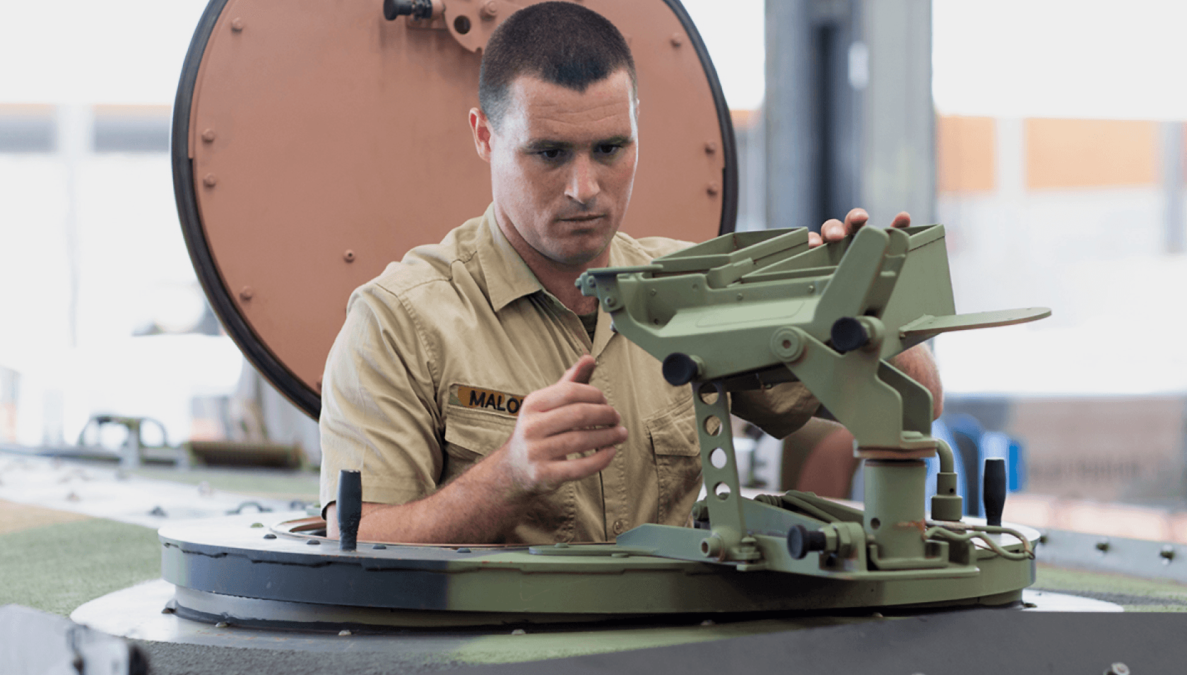 A member of the Army works on a tank.