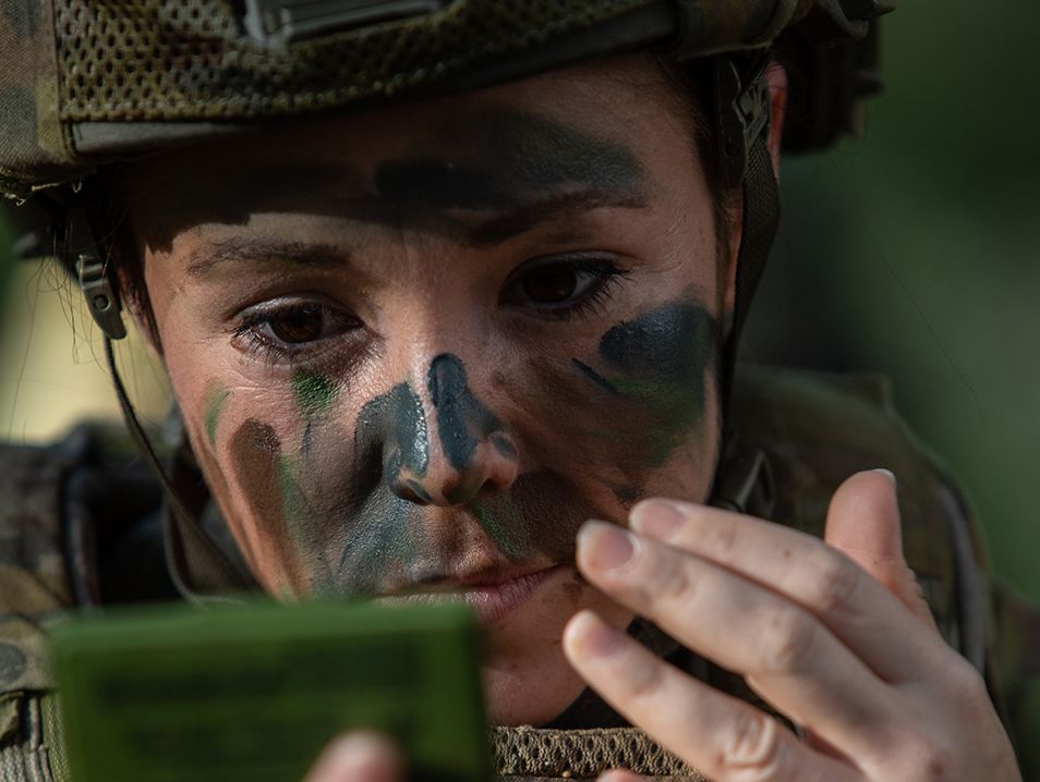 Victoria pains camouflage on her face.