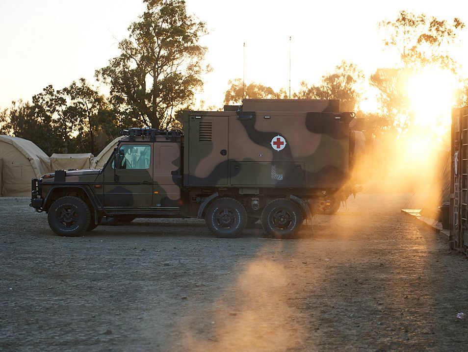 A parked camouflage medical truck.