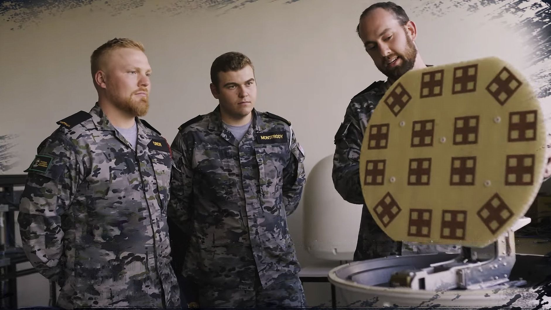 Electronics Technician Bronson talks through some tech with his colleagues.