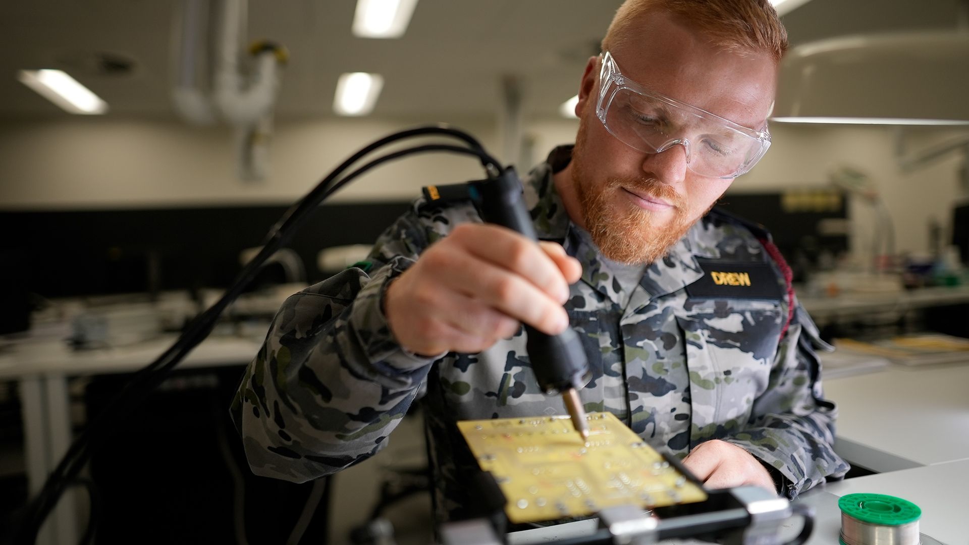 Electronics Technician Bronson works on a motherboard.