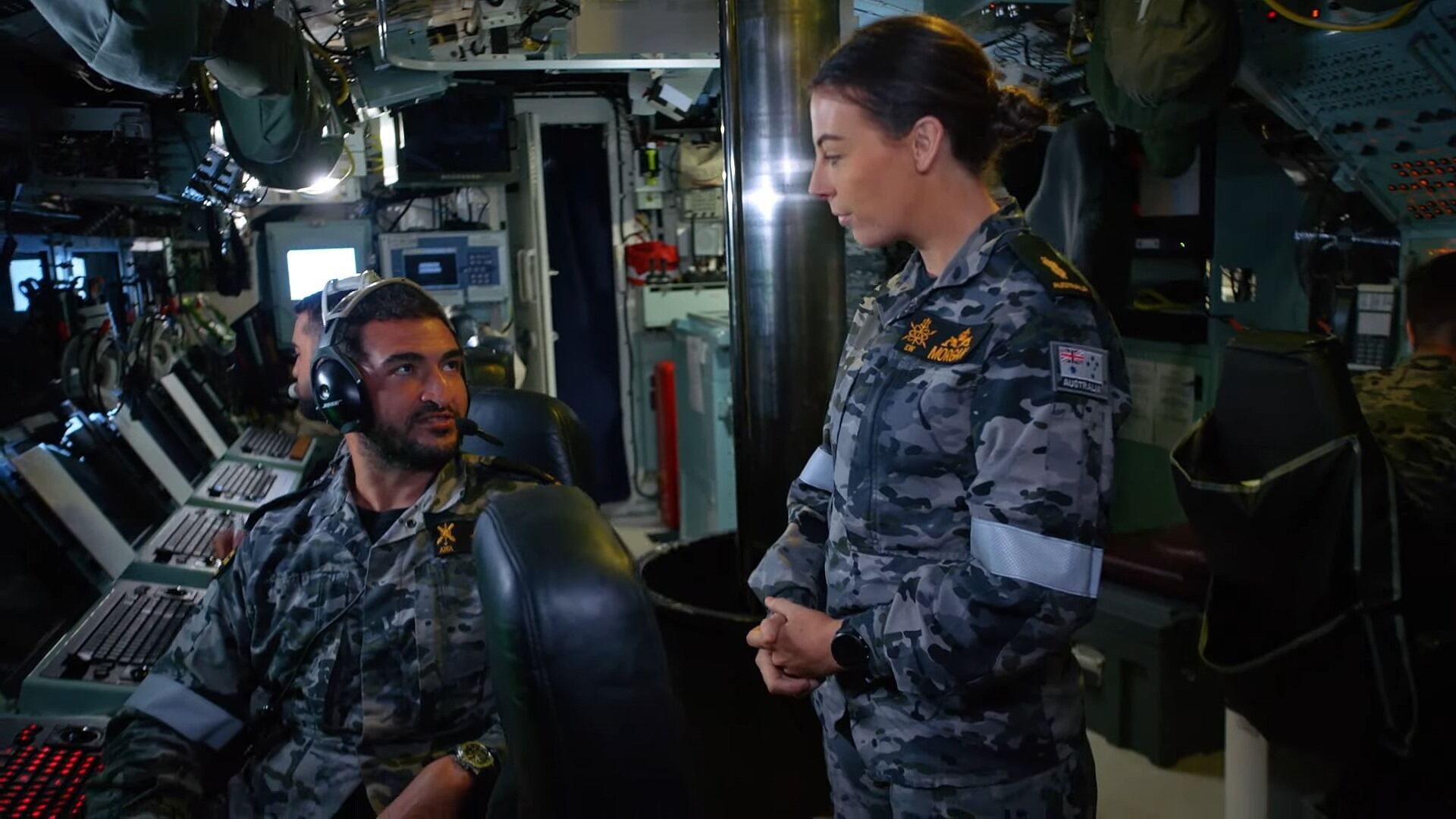 Two submariners are in conversation onboard the vessel.