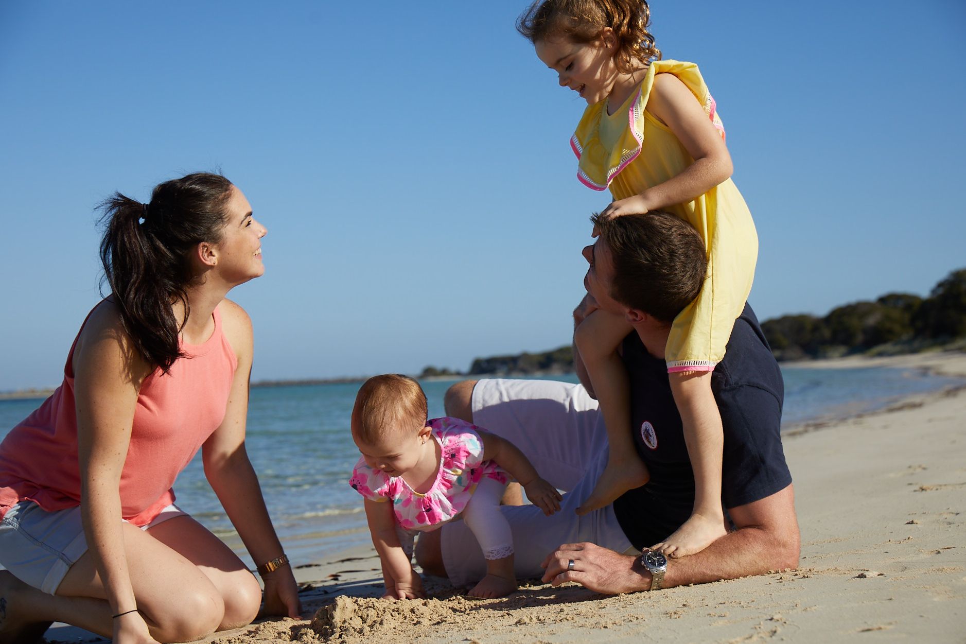 A family playing together outside on the beach.