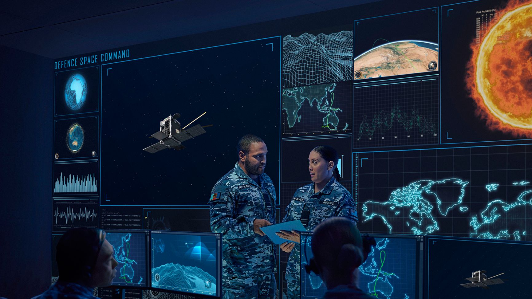 Multiple members of the Air Force standing in front of computer screens.