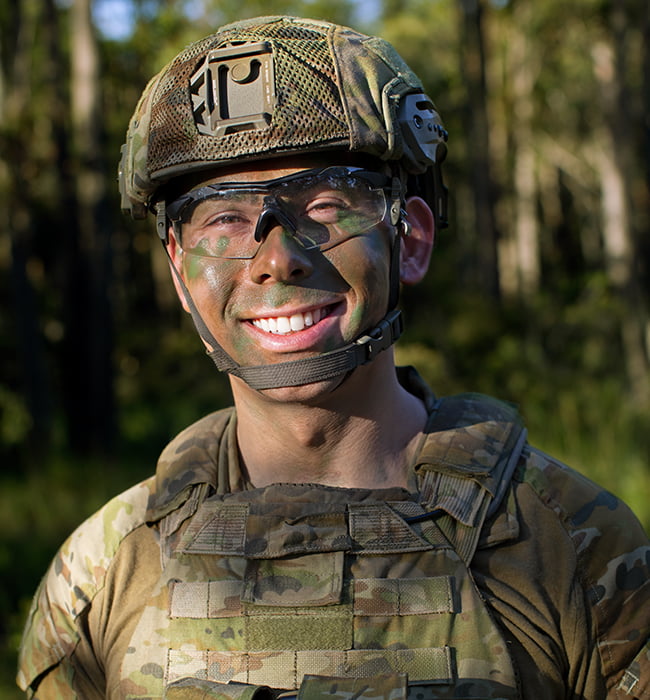 Army Reserve Infantry Soldier Simon is in full camouflage gear,  smiling at camera.