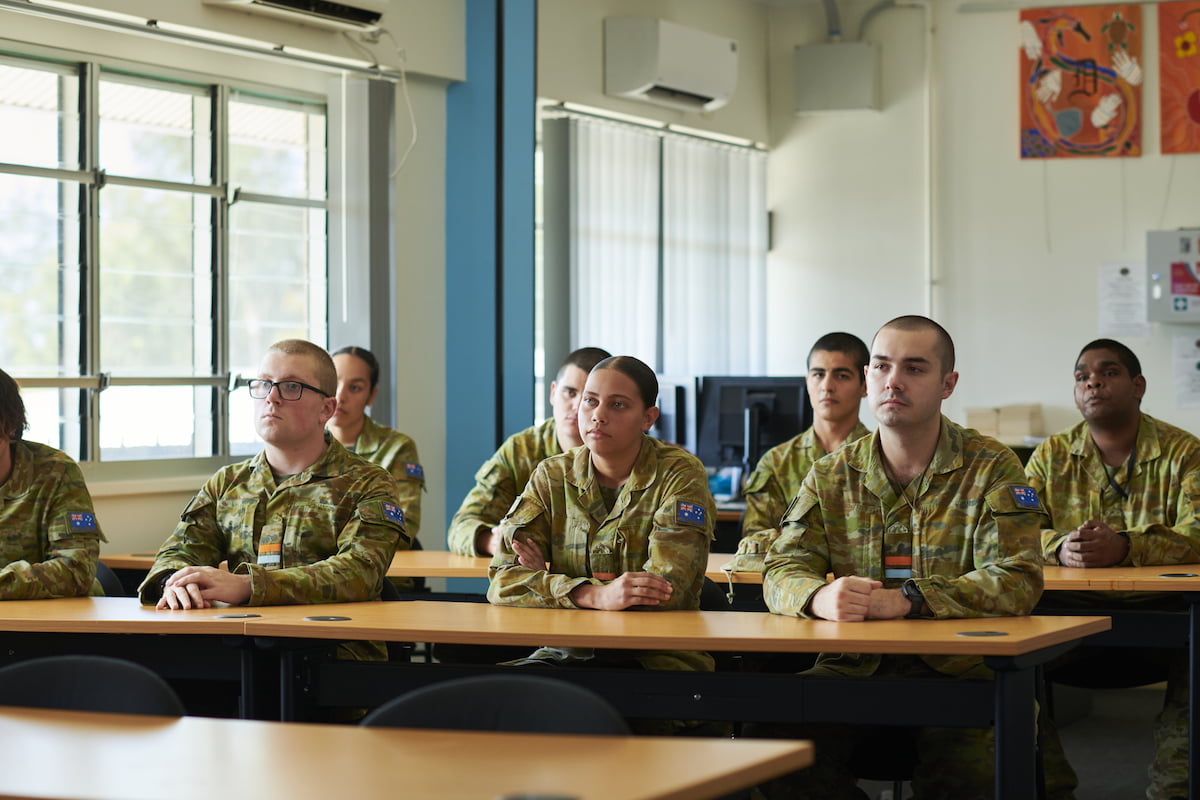 A classroom of cadets pay attention.
