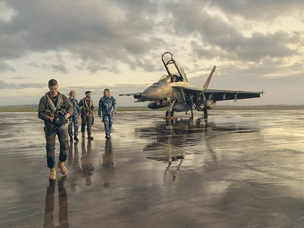 Multiple members of the Air Force walking in front of an airplane.