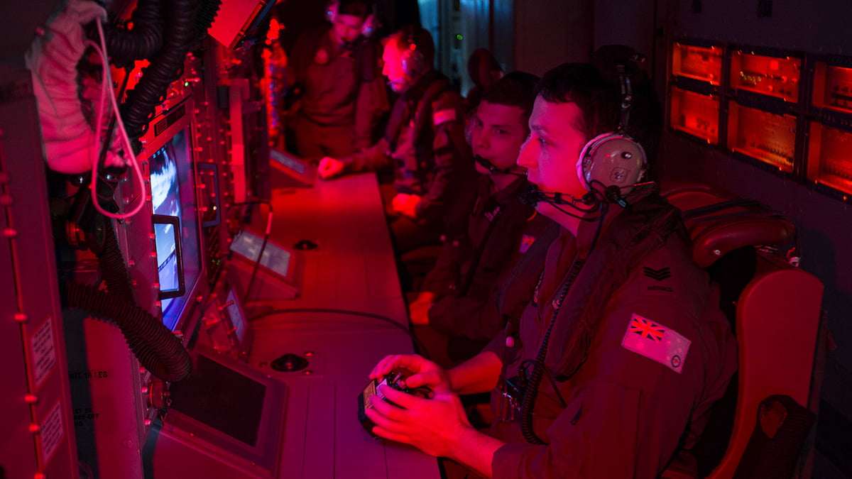 Multiple members of the Air Force looking at a computer screen.