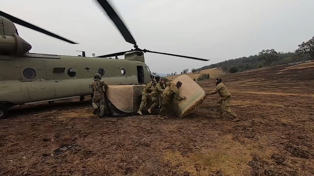 A team of Reservists carry supplies from a helicopter.